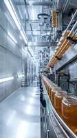 Modern automated beverage production line with glass bottles moving through industrial factory machinery and stainless steel equipment for manufacturing processes.