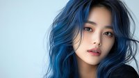 Young Asian woman with vibrant blue dyed hair and natural makeup wearing black top against light background, beauty and fashion portrait with soft lighting.
