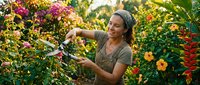 Woman with gray hair and medium skin tone harvesting flowers in vibrant garden, holding pruning shears among blooming plants for floristry, gardening, and agricultural content.