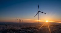 Wind turbines generating renewable energy at sunrise with golden sunlight and clear sky creating sustainable power landscape for environmental projects.