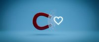 Red horseshoe magnet attracting white heart symbol on blue gradient background representing love attraction, romance magnetism and relationship concepts.
