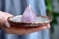 Woman holding copper bowl with purple amethyst crystal pyramid for meditation, healing rituals, spiritual wellness and holistic therapy practices.