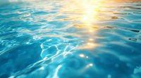 Tranquil turquoise ocean water surface with sunlight reflection creating golden sparkles and ripples. Serene aquatic background for wellness, meditation and spa designs.