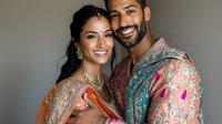 Smiling South Asian couple in traditional wedding attire with ornate embroidered outfits and jewelry against neutral background. Celebration of cultural heritage.