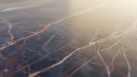 Abstract network connections with glowing orange lines on dark surface creating futuristic digital web pattern for technology backgrounds.