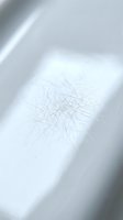 Microscopic view of fine fibers or filaments scattered on white surface with soft lighting and shadows for scientific research applications.