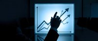 Business professional silhouette pointing at growth chart with upward arrows on illuminated screen in dark office environment for financial success presentations.