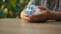 Hands holding glowing crystal ball with digital bar chart hologram, representing business forecasting, data analytics, and future financial growth predictions.