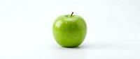 Fresh green apple with water droplets isolated on white background, suitable for food, nutrition, and healthy lifestyle design projects.