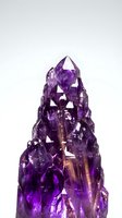 Purple amethyst crystal cluster with pointed formations isolated on white background for healing, meditation and spiritual wellness concepts.