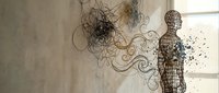 Wireframe human figure dissolving into flowing abstract lines and particles against textured wall background. Mental health and transformation concept for therapy designs.