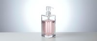 Elegant pink perfume bottle with clear glass design and silver pump dispenser on white surface against gradient background for luxury cosmetics.