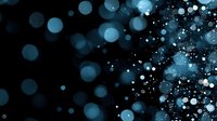 Glowing blue bokeh lights scattered on black background create magical atmosphere with blurred circles and sparkles for festive designs and overlays.