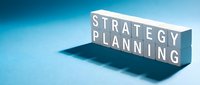 White wooden blocks spelling STRATEGY PLANNING on blue gradient background with shadow, business concept for corporate development and goal setting.