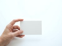 Hand holding blank white business card on isolated background, suitable for branding, corporate identity, and marketing mockup designs.