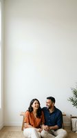 Couple sitting together on wooden bench against white wall, holding hands in modern minimalist interior space with natural light and potted plant.
