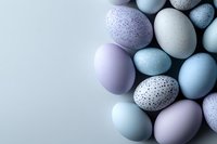 Pastel colored Easter eggs in soft purple and blue shades with speckled patterns arranged on light background, creating gentle spring holiday composition.