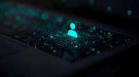 Glowing turquoise user profile icon on dark laptop keyboard with bokeh light effects, representing digital identity and cybersecurity in modern technology.