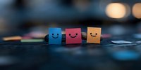 Colorful paper notes with happy smiling faces arranged in row on dark background with soft bokeh lights creating positive emotional atmosphere.