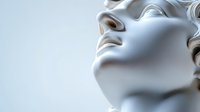Classical marble sculpture profile with curly hair and serene expression against soft gray background for art history education and cultural content.