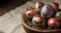 Traditional painted Easter eggs with intricate folk art patterns displayed in rustic wooden bowl with moss for spring holiday celebration and decoration.