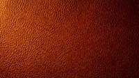 Textured leather surface in warm rust and burnt orange tones, featuring a quilted diamond pattern. Suitable for backgrounds, design projects, and material references.