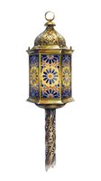 Ornate brass lantern with blue and gold geometric patterns, featuring intricate metalwork and decorative details. Isolated on white background, ready for design projects.