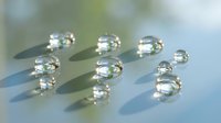 Crystal clear water droplets on smooth surface creating natural reflections and shadows for spa wellness and purity concepts.