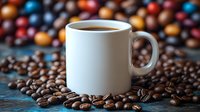 White ceramic coffee mug surrounded by scattered roasted coffee beans on rustic blue surface with colorful blurred bokeh background creating cozy morning atmosphere.