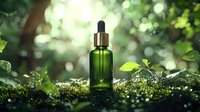 Green glass dropper bottle on moss with natural bokeh forest background, organic skincare concept with morning dew drops and fresh leaves in sunlight.
