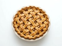 Freshly baked apple pie with golden lattice crust in ceramic dish, isolated on white background for bakery, food, and culinary design projects.