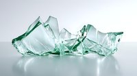 Shattered pieces of transparent green glass scattered on reflective surface with soft shadows and highlights creating dramatic composition for safety concepts.