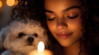 Young African American woman with curly hair and closed eyes holding small white dog in warm candlelight creating intimate atmospheric portrait with bokeh lighting effects.