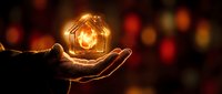 Hands holding glowing house icon with warm bokeh lights background representing home protection, real estate investment, property insurance concept.
