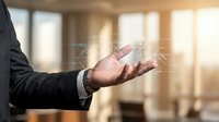 Businessman in dark suit with watch gestures with open palm in modern office with sunlight, representing communication, agreement, or presentation concept for corporate business themes.