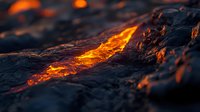 Glowing hot lava flow breaks through dark volcanic rock surface, creating dramatic contrast between molten magma and cooled basalt formations in close-up view.