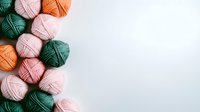 Colorful yarn balls in pink, orange and green shades arranged on white background. Knitting and crochet supplies composition with copy space for crafting projects.