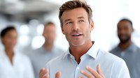 Confident middle-aged Caucasian businessman in white shirt gesturing while speaking to colleagues in modern office environment for corporate presentations.