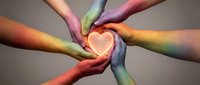 Multiple diverse hands forming heart shape with rainbow light projection, symbolizing unity, love, and inclusive community support.