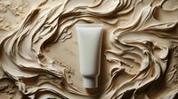 Cosmetic tube surrounded by swirling beige cream texture creating dynamic flowing patterns for skincare and beauty product advertising.