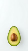 Fresh avocado half with pit isolated on white background for healthy cooking and nutrition concepts.