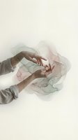 Gentle hands reaching through flowing translucent fabric in soft pastel colors creating ethereal artistic composition for wellness and mindfulness concepts.