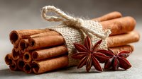 Aromatic cinnamon sticks bundled with rustic twine and star anise spices on textured surface, perfect for culinary, holiday, or seasonal designs.