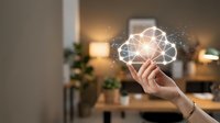 Hand holding glowing cloud computing network icon with connected nodes and light effects in modern office environment for digital transformation concepts.