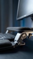 Modern smartwatch with sport band on office desk next to laptop computer in contemporary workspace for fitness tracking and productivity.