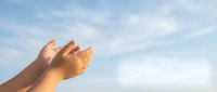 Open hands reaching toward bright blue sky with soft white clouds, symbolizing hope, prayer, freedom, and spiritual connection with nature.