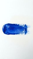 Blue paint brush stroke on white background with textured edges and artistic smudge effect for creative design projects.