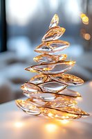 Spiral arrangement of crystal glass elements creating abstract Christmas tree shape with golden light bokeh and soft focus background for festive design.