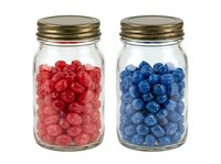 Red and blue raspberries and blueberries in glass jars with brass lids, isolated on white background for food packaging, culinary design, and product mockup use.