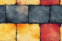 Colorful stone blocks pattern with yellow, orange, red and gray squares arranged in rows, featuring textured surface and weathered appearance. Architectural detail.